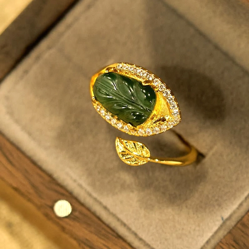 Natural jade leaf gold ring displayed in beige velvet jewelry gift box - top-down side view showing elegant presentation and packaging