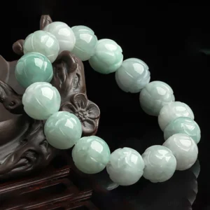 Hand-carved jade lotus beads bracelet displayed on wooden lotus ornament, three-quarter view showing smooth polished finish
