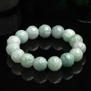 Natural jade lotus carving bracelet with gradient light green and white beads, carved lotus details, overhead flat lay on black studio background