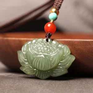 Carved cyan jade lotus pendant with intricate petal details and gold-tone beads, three-quarter angle close-up
