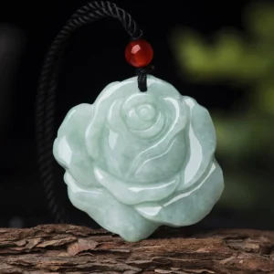 Jade rose pendant necklace front flat lay showing intricate lotus carving, black cord, and red accent bead detail
