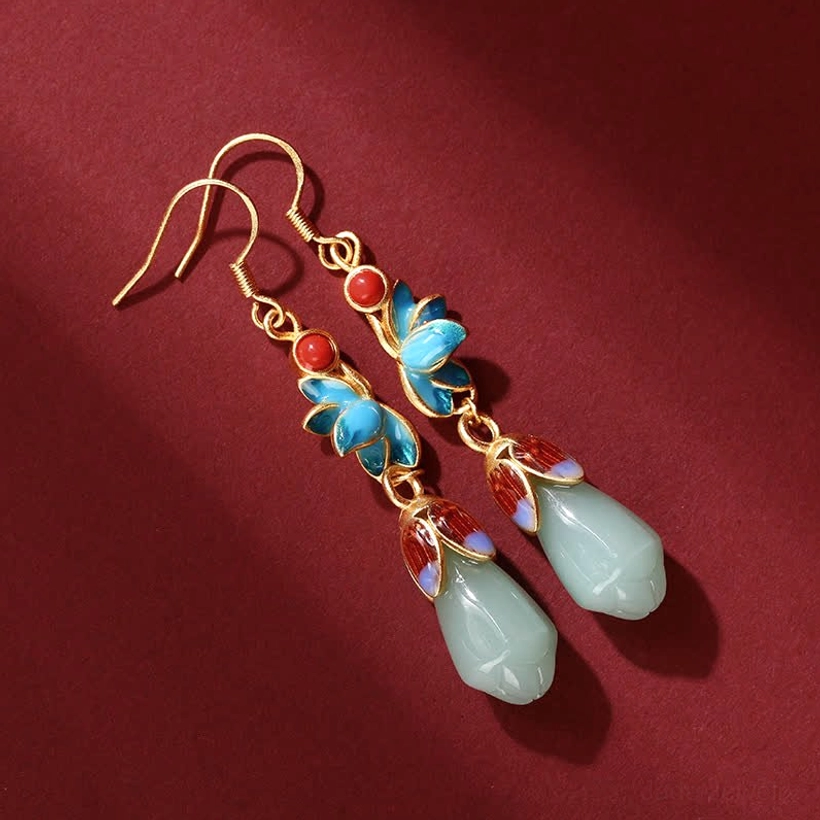 Overhead angled view of magnolia jade earrings featuring vibrant blue and red enamel floral details with natural jade pendants