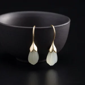 pair of magnolia jade drop earrings displayed on ceramic bowl sterling silver jewelry