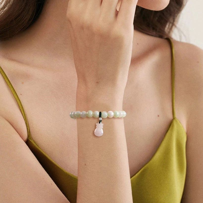 Wearable jade charm bracelet on wrist showing pale pinkish jade beads and drop pendant in fashion setting, model wear demonstration