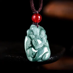 Hand-carved green jade kitsune fox pendant showing intricate carving details and symbolic design