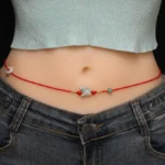 Jade peace buckle red string belly chain with zodiac charm on-body waist view, braided red cord with jade and cinnabar beads
