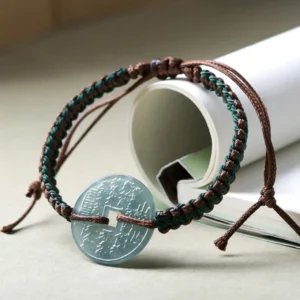 Hand-woven jade peace buckle bracelet showing adjustable knot closure and carved round jade pendant