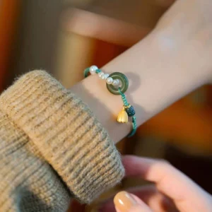 Close-up adjustable jade peace buckle bracelet with dark green decorative beads and braided strap detail