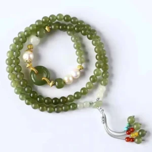 Dark green jade beaded bracelet with peace buckle charm flat lay - prosperity jewelry