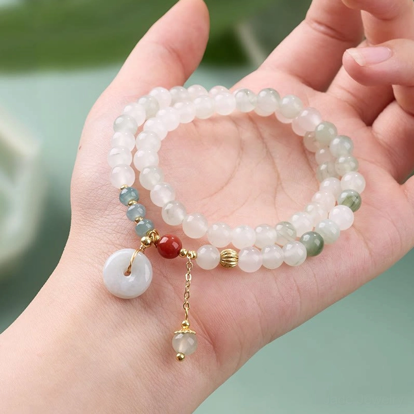 Green jade peace buckle bracelet held in hand showing full wrapped design and sizing