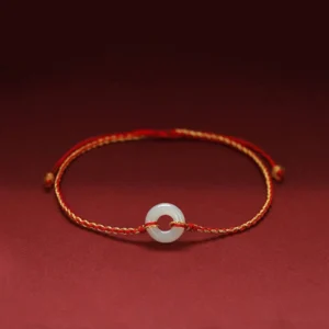 Jade peace buckle braided bracelet with red string, featuring round white jade charm on premium braided cord, front view