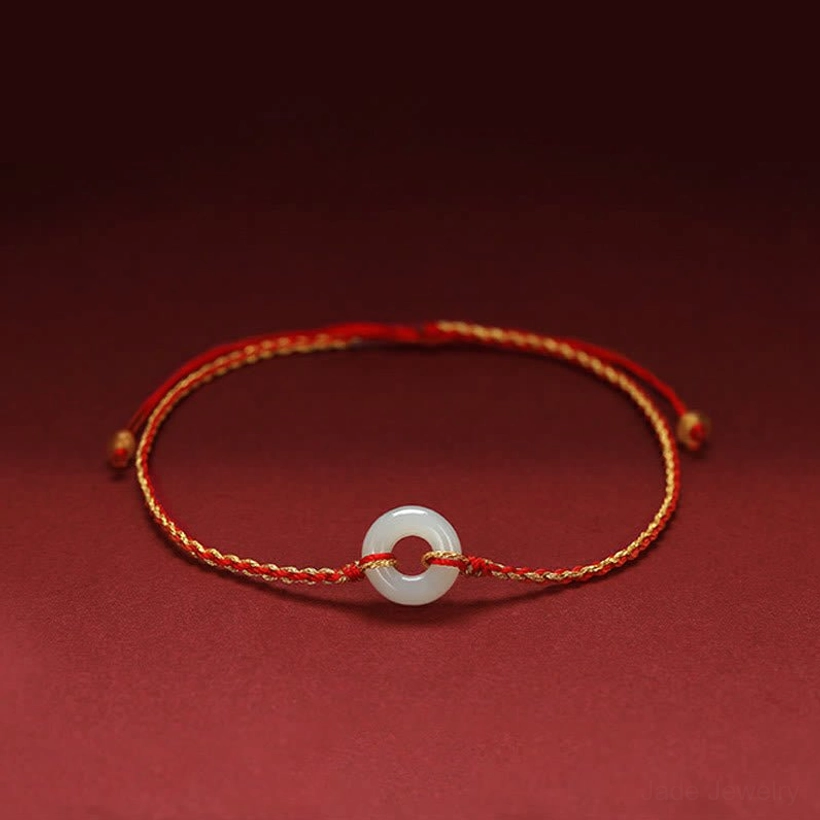 Jade peace buckle braided bracelet with red string, featuring round white jade charm on premium braided cord, front view