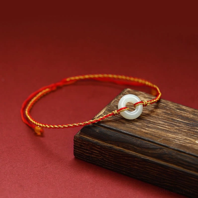 Side angled view of handcrafted jade peace buckle bracelet showing braided red and golden rope texture with decorative accent beads