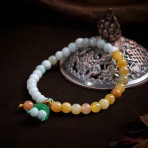 Top-down view of jade lotus peace buckle prosperity bracelet on vintage metal ornament, featuring pale blue, yellow and white natural stone beads