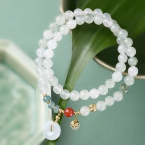 Close-up jade peace buckle bracelet showing white jade beads red agate and blue stone accents with peace buckle charm