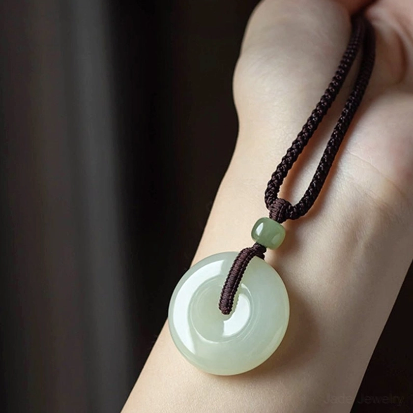 Natural jade peace buckle showing authentic handcrafted texture and character variations unique artisan quality