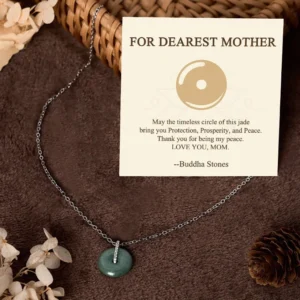 Jade peace buckle sterling silver necklace for mother gift with delicate silver chain and round green jade pendant on warm vintage table