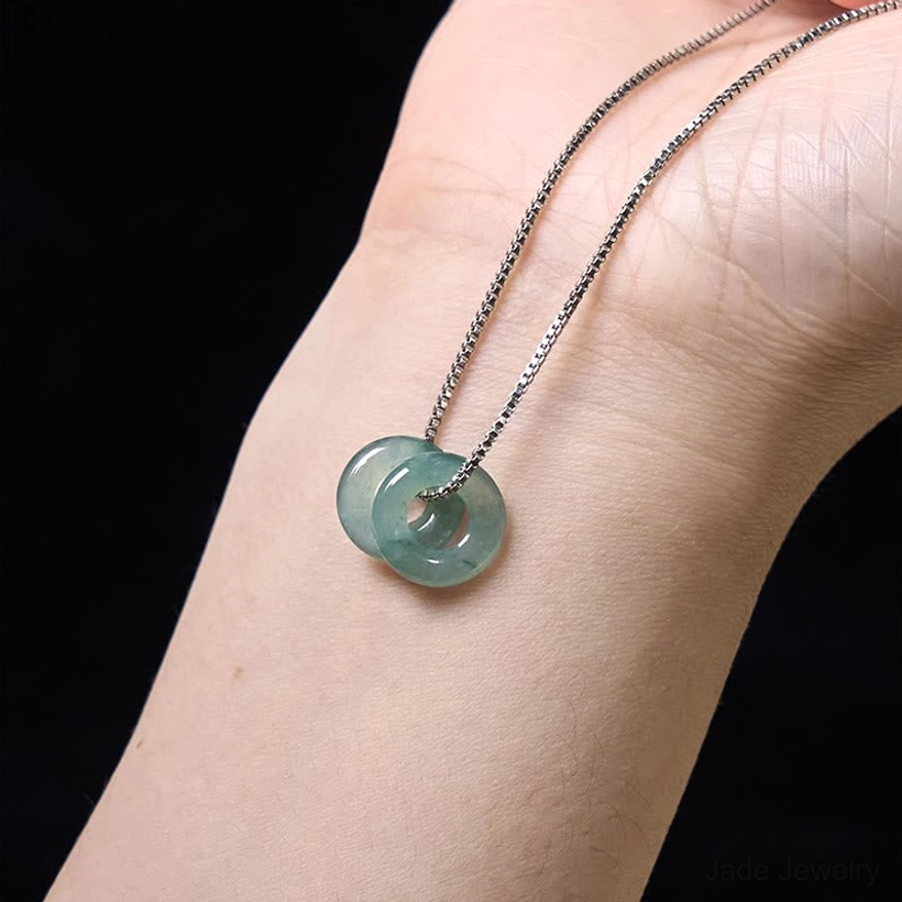 Natural jade double peace buckle pendant showcasing authentic color variation and artisan hand-carved quality