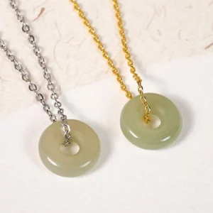 Two natural jade peace buckle necklaces side by side, gold and silver copper chains, flat lay comparison