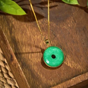 Gold-toned peace buckle jade pendant necklace - side angle view showing intricate bezel craftsmanship with botanical styling