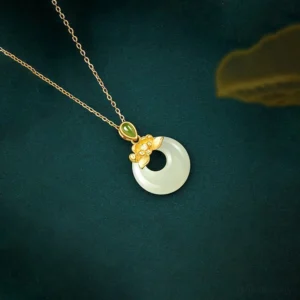 Sterling silver jade peace buckle pendant necklace, three-quarter close-up shot showing delicate chain and round pale jade donut pendant