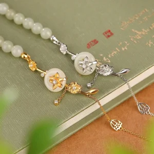 Dual-style jade peace buckle bracelets with sterling silver and gold plating options featuring lotus charms on vintage book desktop