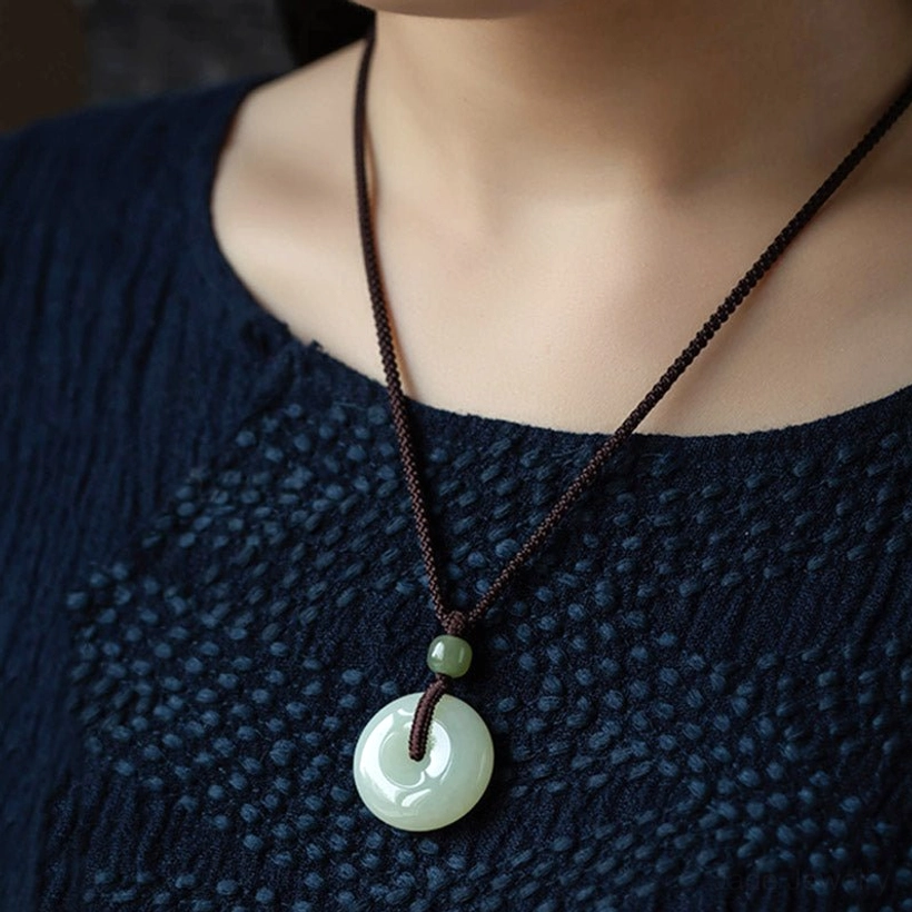 Jade peace buckle necklace worn on female neck overhead view classic minimalist pendant design on neckline