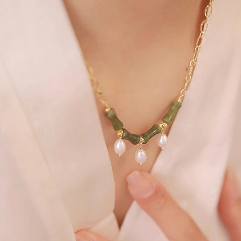 Close-up detail of Tianshan jade bamboo pearl necklace pendant and pearl drops on model