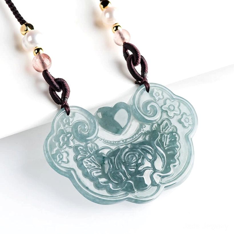 Jade lock pendant necklace with pink and white beaded chain, overhead angle view showing intricate carving details and mixed bead accents
