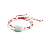 Natural jade Pi Xiu wealth bracelet with red protective cord, adjustable sliding knot design, top-down side view showing carved jade bead and woven red string