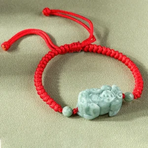 Jade Pixiu bracelet reverse side overhead angle displaying adjustable sliding knot on red woven cord