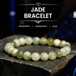Natural jade prosperity bracelet with mixed light and deep green round polished beads on dark stone display base