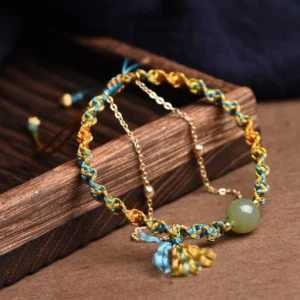 Double layer jade abundance bracelet with metal chain and tassel pendant, artisanal craftsmanship detail