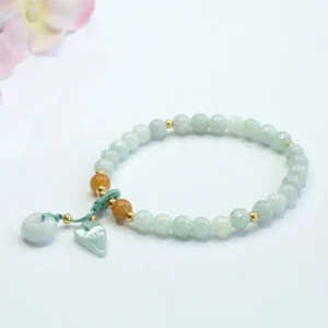 Side view of authentic green jade beaded prosperity bracelet with decorative charms