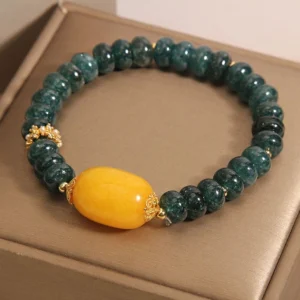 Handmade jade prosperity bracelet side view showing uniform dark green rondelle beads and gold hollow spacers