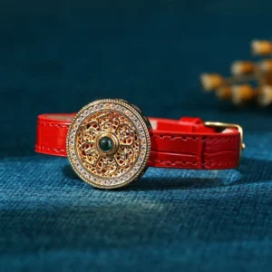 Six True Words jade bracelet flat lay showing red crocodile-textured leather band with intricate gold filigree medallion and jade centerpiece