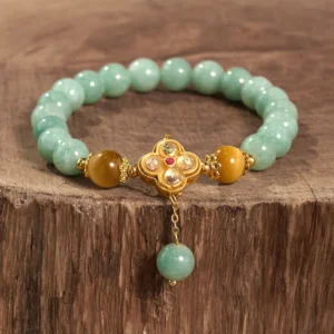 Top view of jade prosperity bracelet showing mint green beads with amber and gold tones and decorative metal charm