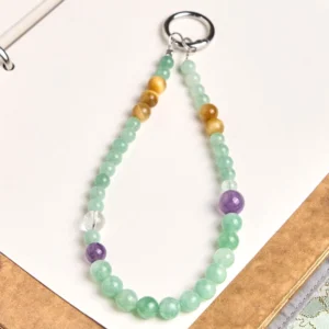 Jade beaded phone charm and keychain with mixed natural stone beads in teardrop design, flat lay on office desk with stationery