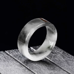 Handcrafted jade prosperity ring featuring cloudy black and white jade texture, flat band style on dark wooden background