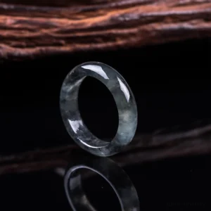 Single natural jade prosperity ring in three-quarter side view, showcasing smooth rounded band and translucent dark grey jade stone