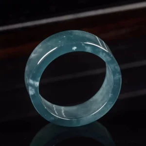 Jade prosperity ring top view, translucent blue stone with natural inclusions, frontal perspective