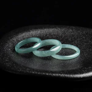 Multiple handcrafted jade prosperity rings polished jadeite bands arranged flat lay top-down view