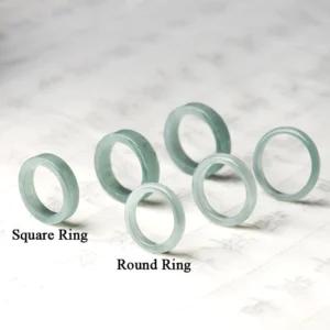 Collection of natural jade prosperity rings in round and square styles with various sizes, top-down flat lay view