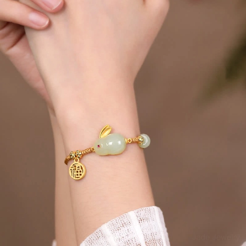 Worn Hetian jade Rabbit bracelet on wrist with white lace sleeve, close-up side view