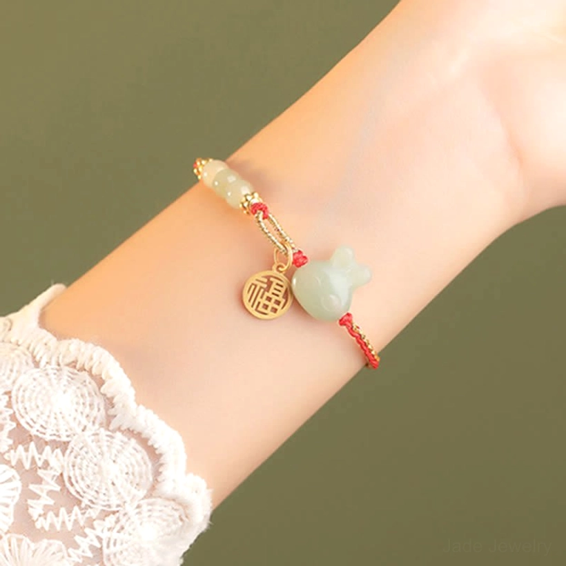 Hetian jade rabbit bracelet worn on wrist with lace sleeve, side view showing delicate design