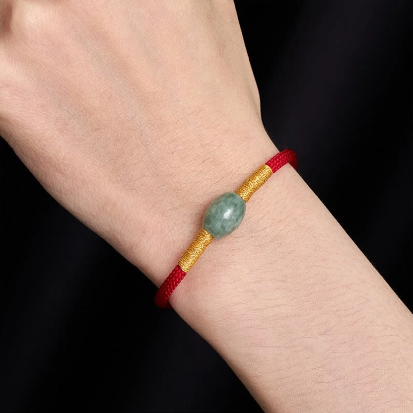 Red jade protection bracelet worn on wrist close-up side view on dark background demonstrating comfort and fit
