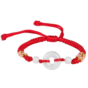 Adjustable red string jade bracelet showing cord ends and symmetrical design details from overhead angle