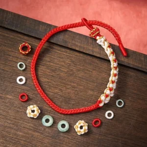 Adjustable jade red string luck bracelet components and spare beads flat lay