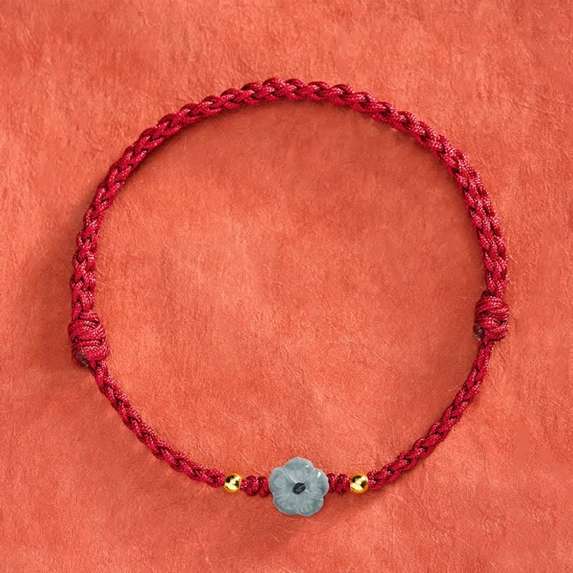Jade red string bracelet flat lay showing full circular design with adjustable knots and central carved jade charm