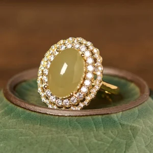 Double halo jade zirconia cocktail ring, top-front view on green ceramic tray, sparkling cubic zirconia details